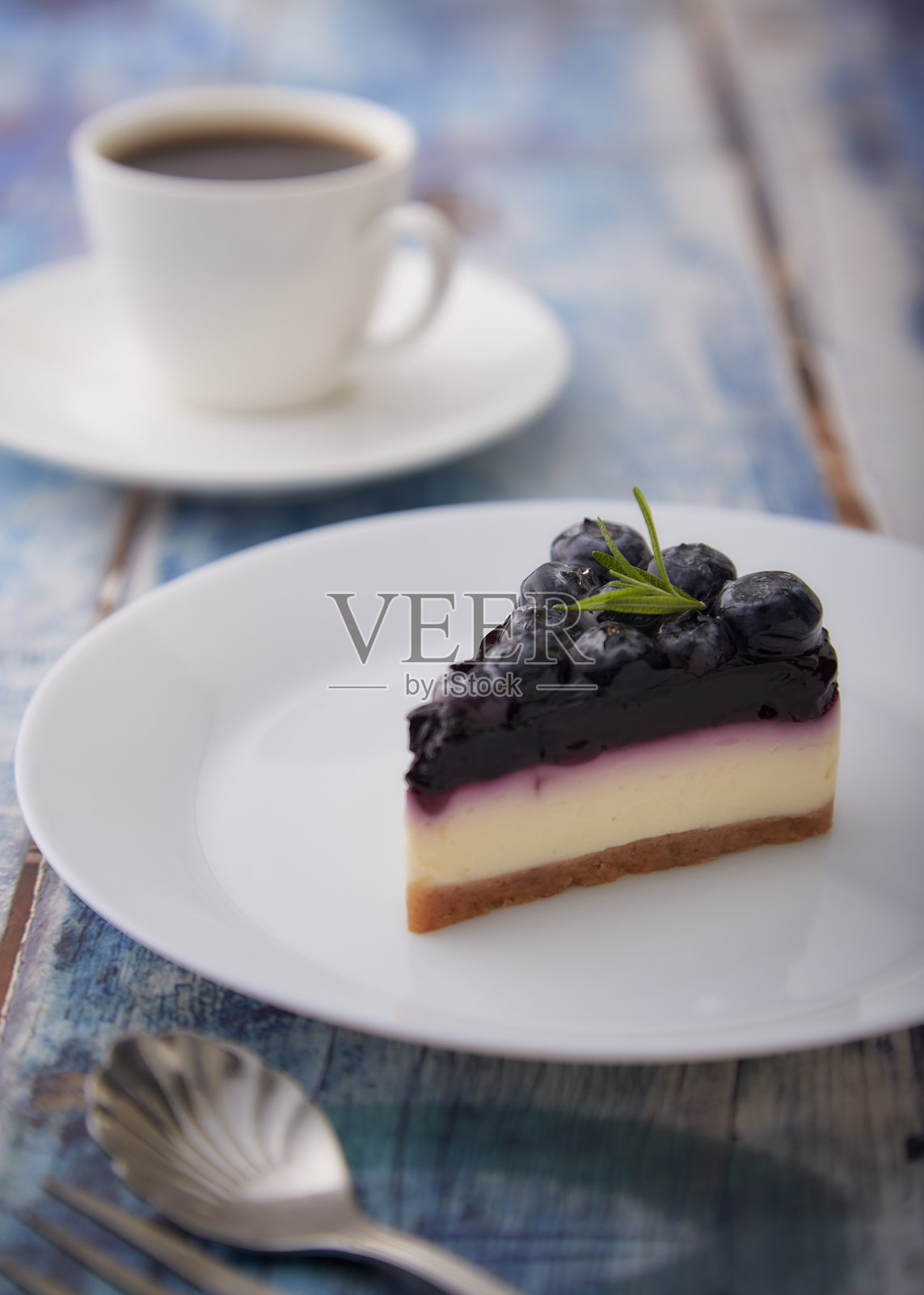 木桌上放着蓝莓芝士蛋糕照片摄影图片