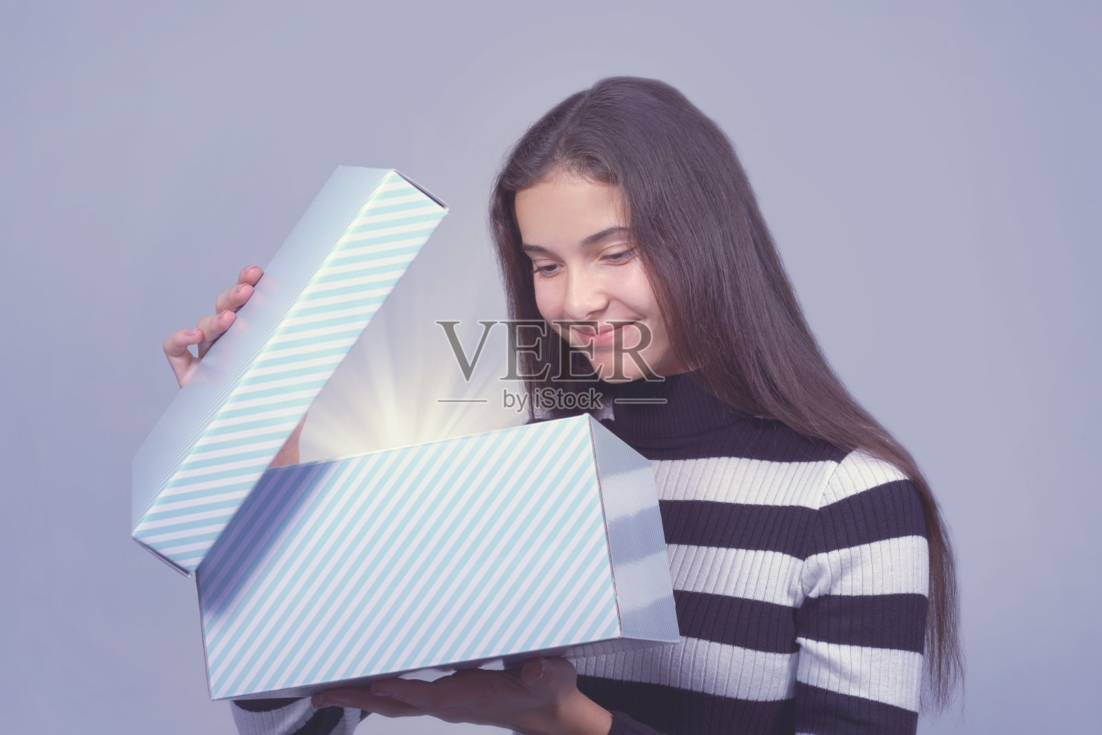 女孩微笑着打开亮灯礼盒的盖子照片摄影图片