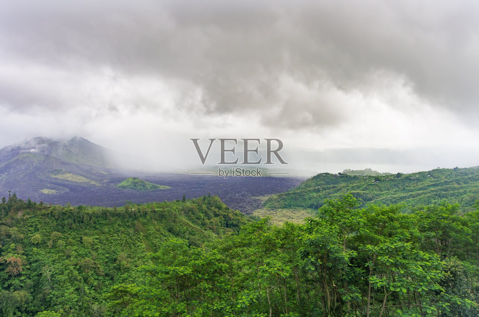 火山阿贡或Gunung阿贡在雨天。神圣的火山和丛林上空的低云。熔岩在山坡上留下痕迹。巴厘岛,印度尼西亚照片摄影图片
