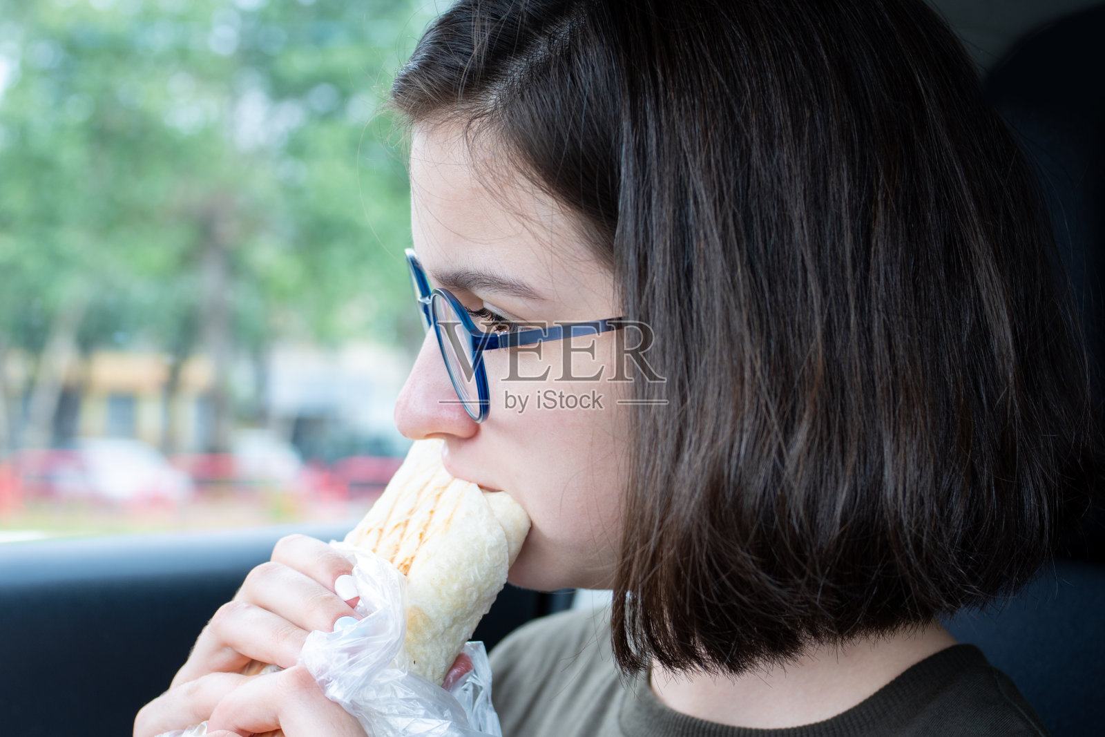 年轻漂亮的女人在吃快餐,特写。不健康食品概念,快餐照片摄影图片