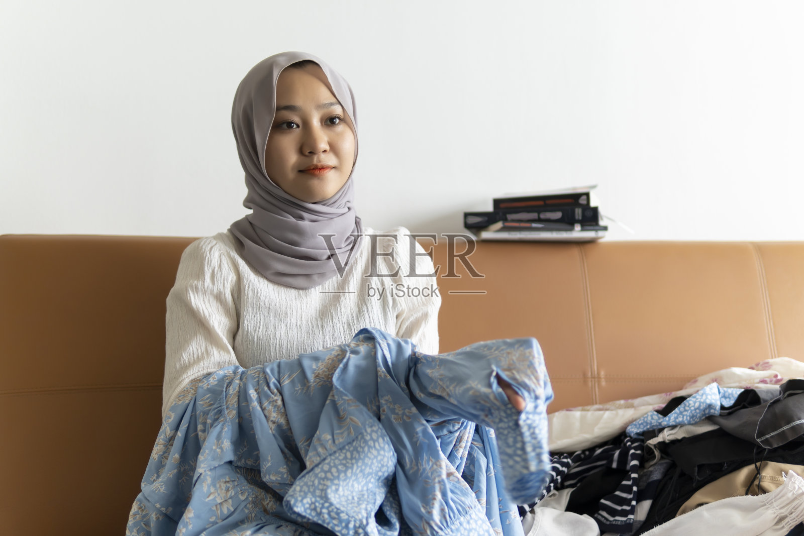 可爱的马来女子做家务折叠她的衣服照片摄影图片