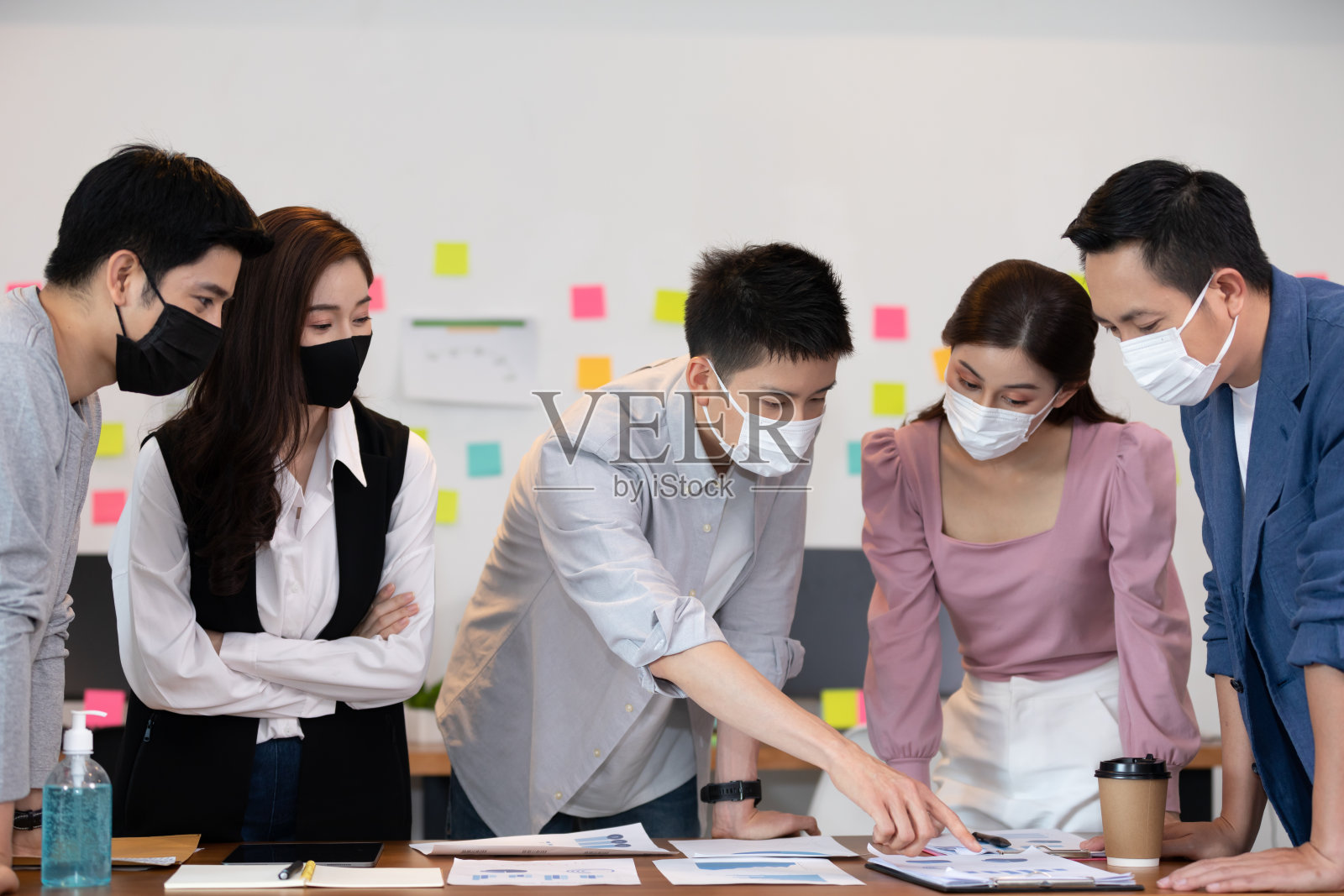 新常态下,一群带着口罩的商务人士聚集在一起,在社会距离较远的情况下进行讨论和头脑风暴,以获得想法或营销解决方案照片摄影图片