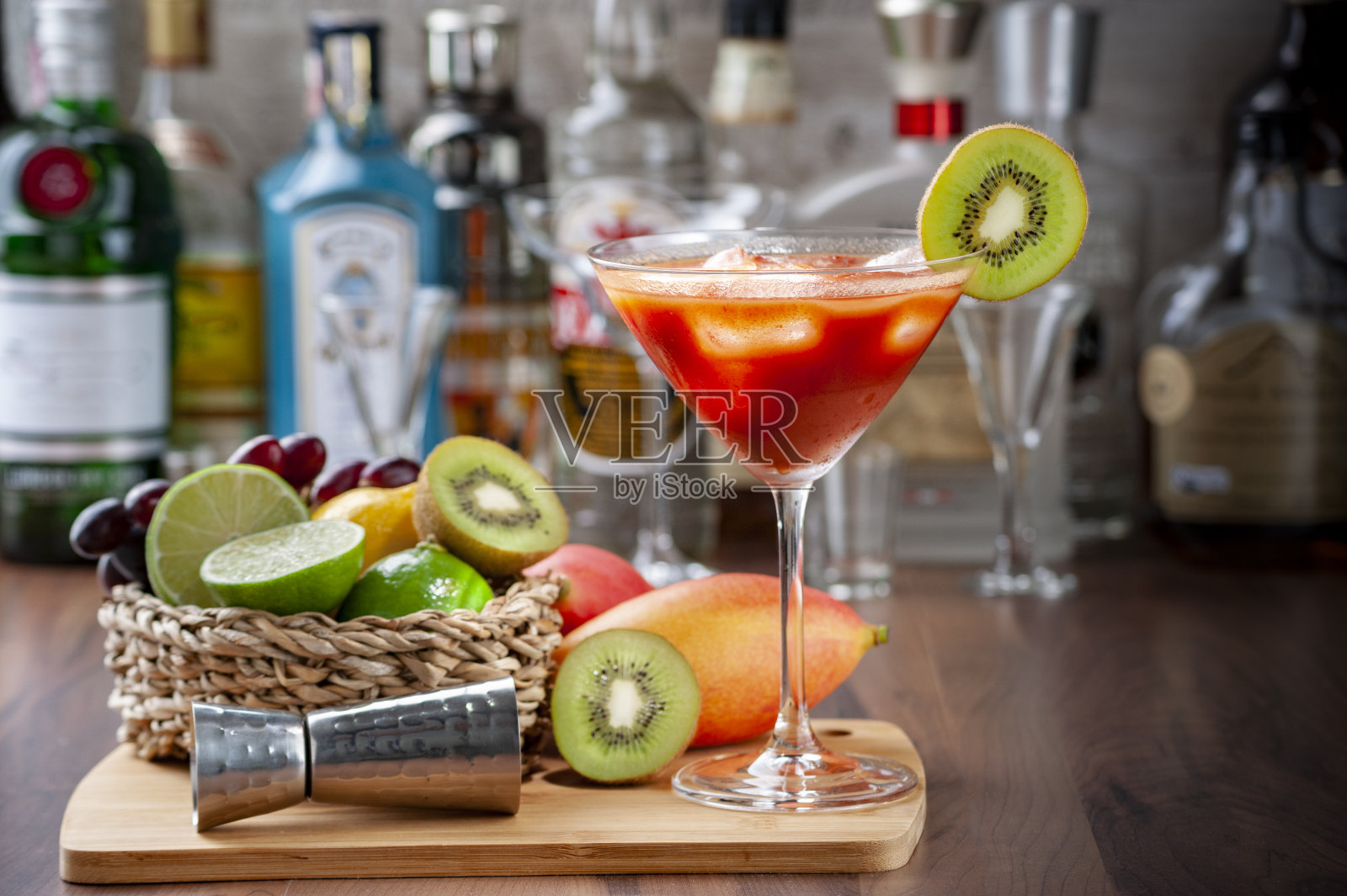 番茄汁装在鸡尾酒杯里,放在吧台的木托盘里。一些水果周围模糊的背景,空间复制照片摄影图片