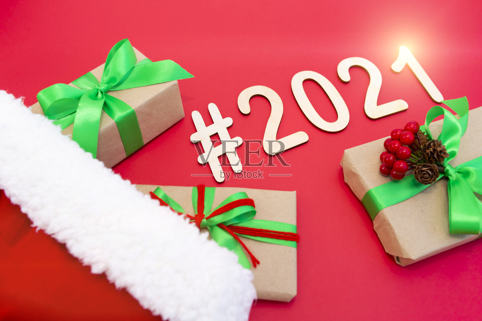 在一顶新年帽子的红色背景上,胶合板数字“2021”照片摄影图片