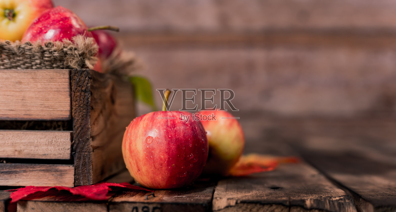 有机成熟的红苹果装在木盒里。秋收丰饶的季节。新鲜水果与木桌背景。照片摄影图片