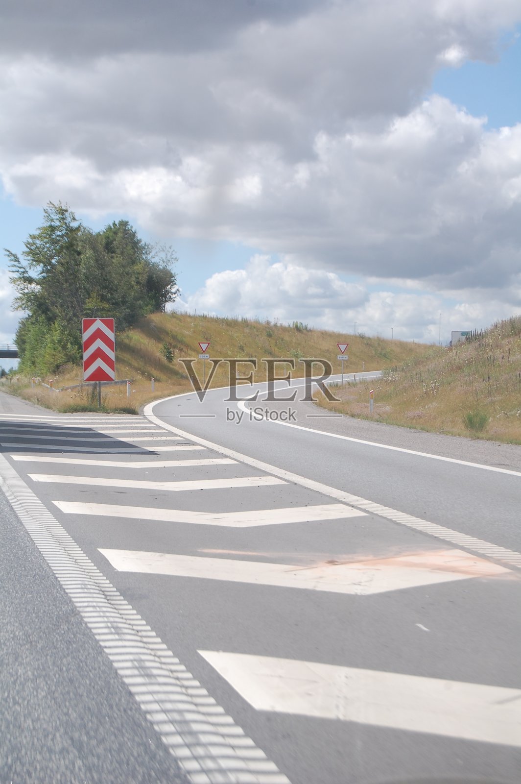 弯弯曲曲的出口弯道,道路标志和分隔标志。照片摄影图片