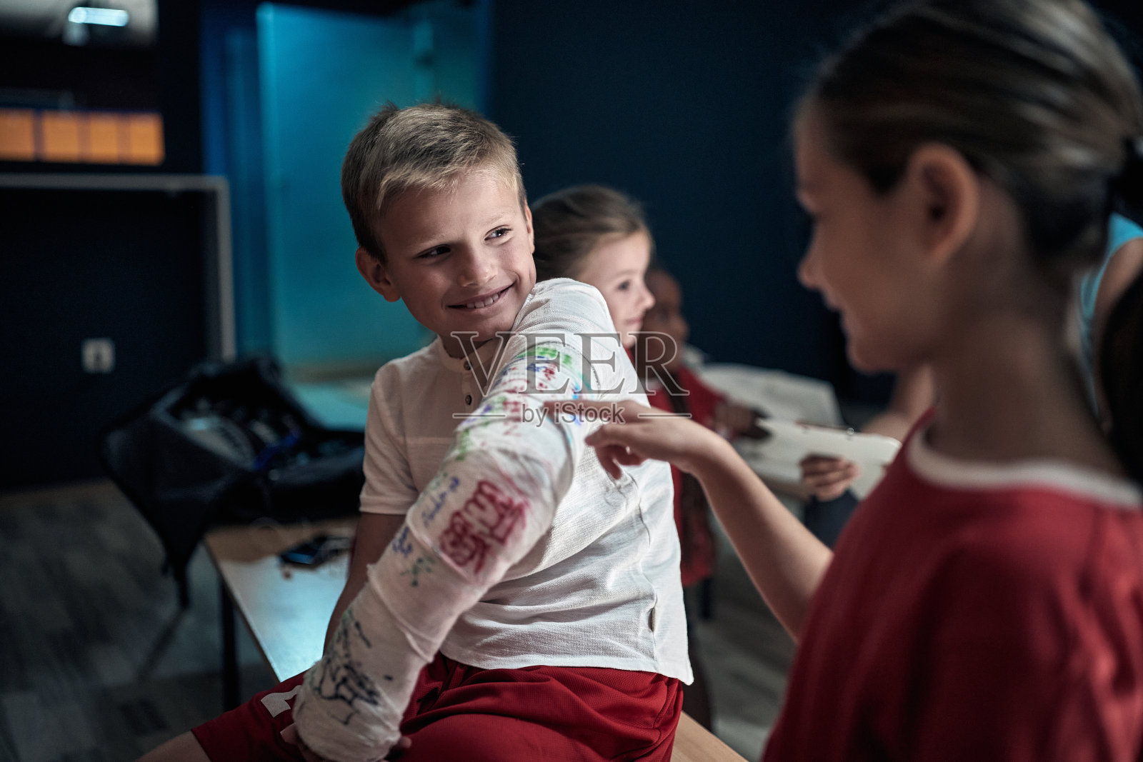 一个小足球运动员受伤了,他的胳膊骨折了照片摄影图片