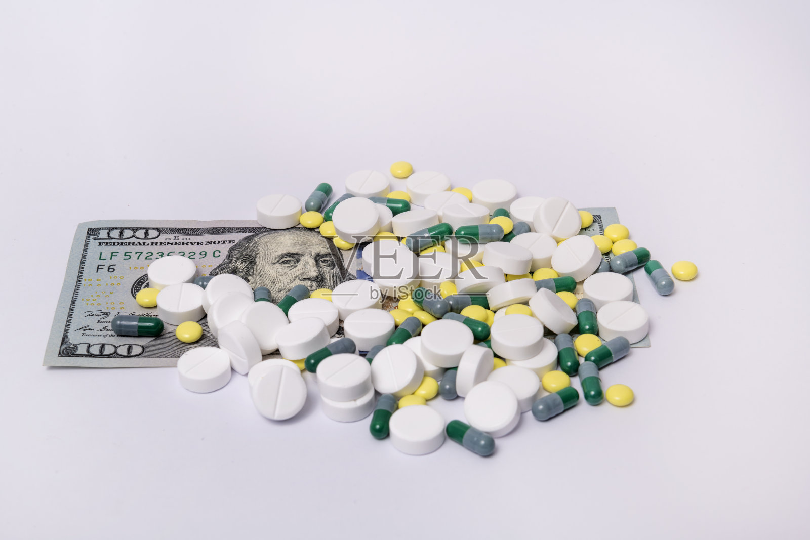 一百美元一杯的杯子上有一堆不同的药片和药物照片摄影图片