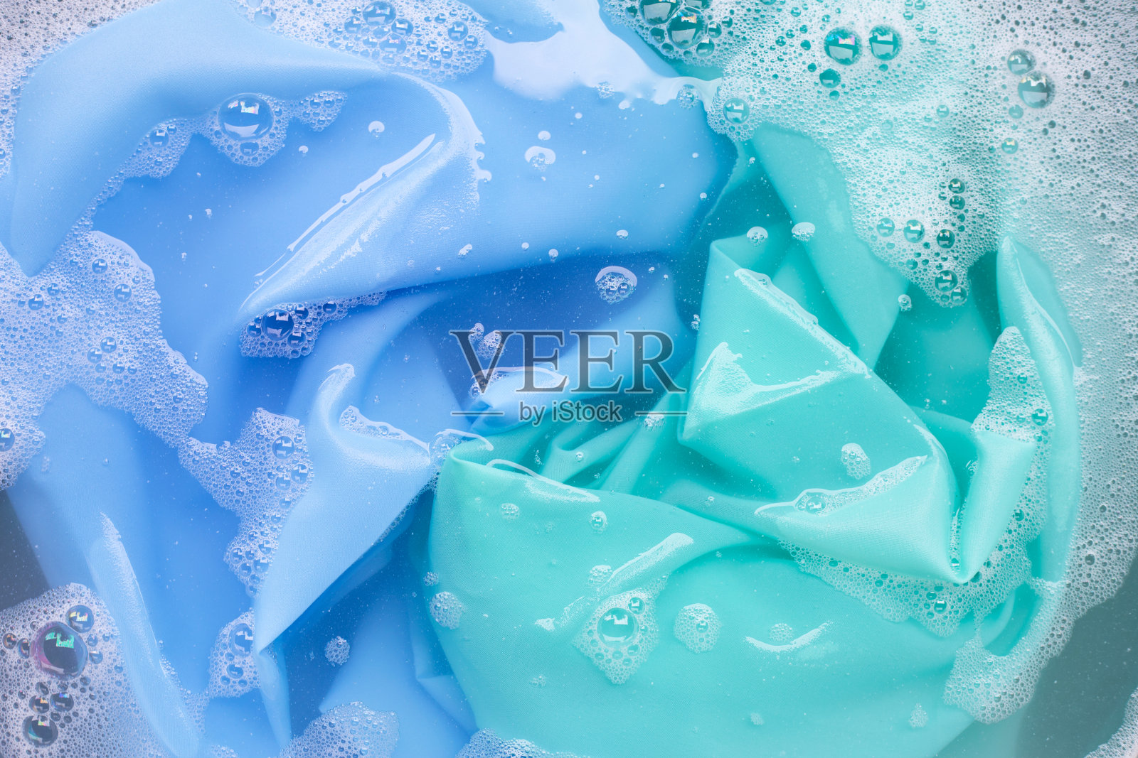 颜色衣服浸泡在洗衣粉水溶解。衣服的概念照片摄影图片