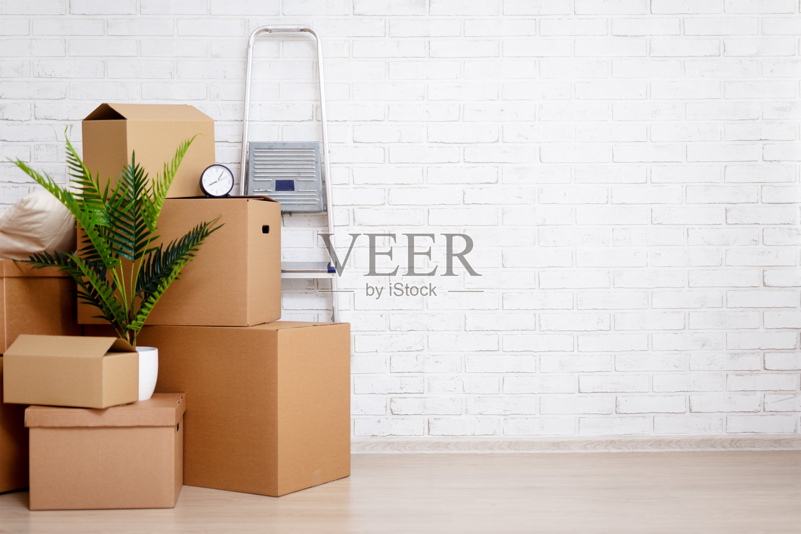 移动的日子概念-纸板箱,室内植物和其他东西在白色砖墙的背景照片摄影图片