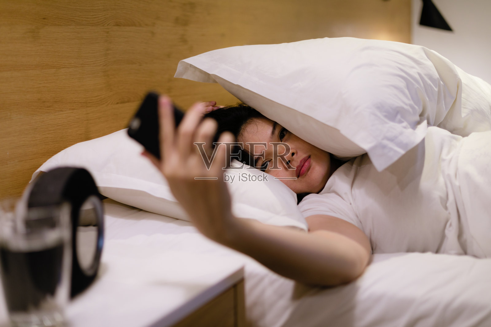 年轻美丽的亚洲女人讨厌她的电话在早上响起照片摄影图片