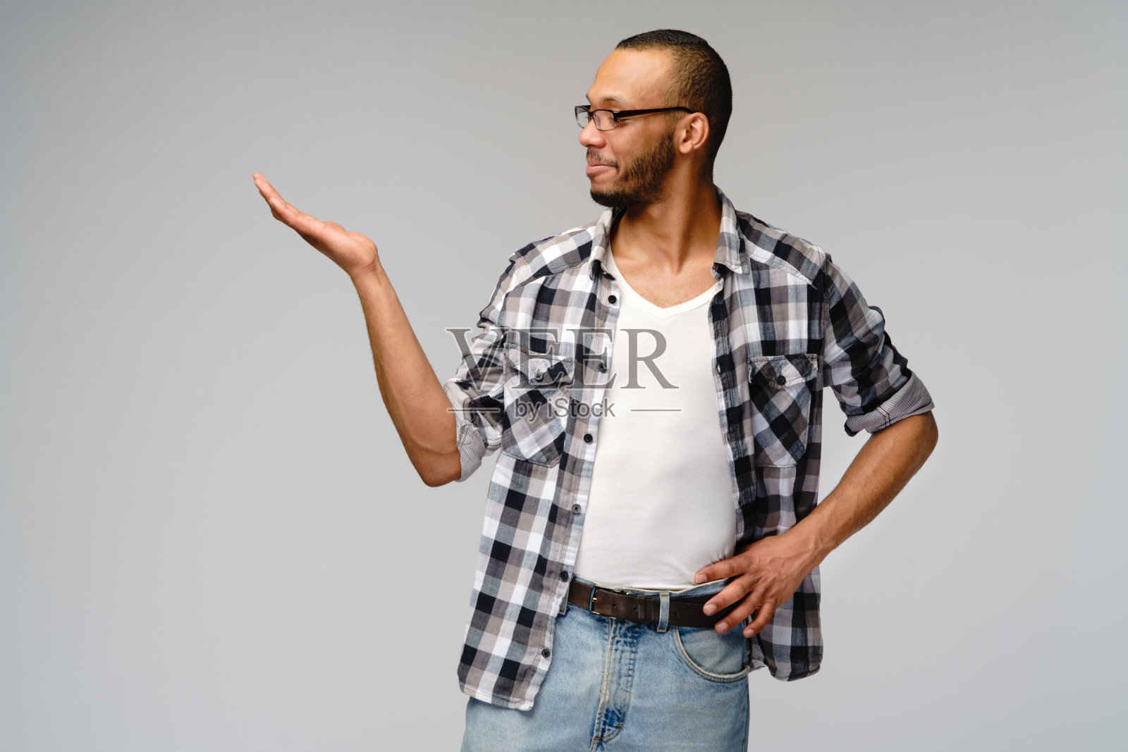 快乐友好的非洲裔美国年轻人穿着休闲衬衫指着复印空间照片摄影图片