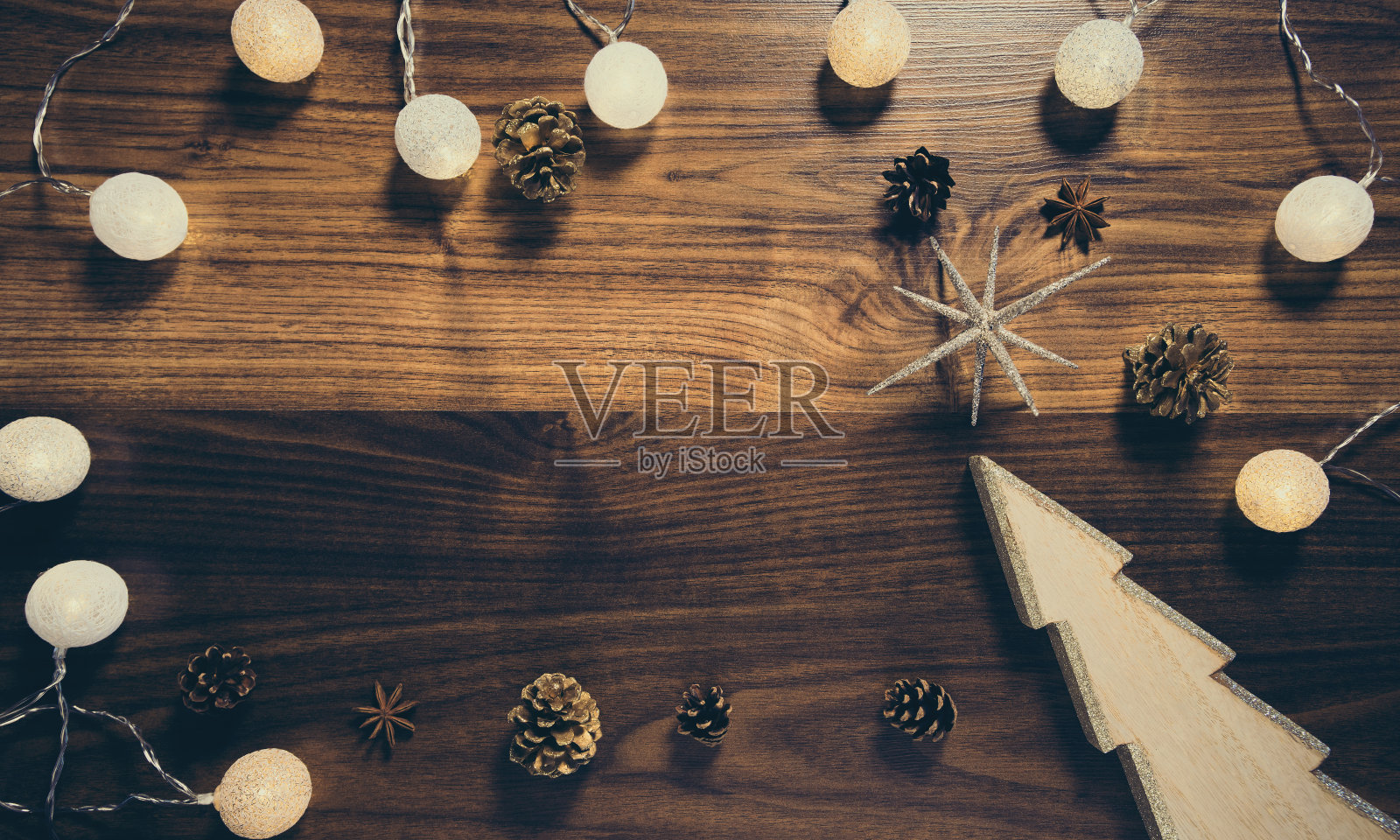 木制背景装饰圣诞树,花环和松果。庆祝和节日的概念。前视图。照片摄影图片