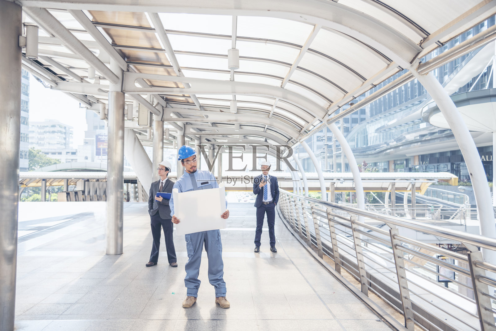 土建工程师团队在施工现场开会,与团队一起穿安全服,信任团队在桌上看蓝图,一起咨询安全安全帽,建设工程师概念照片摄影图片