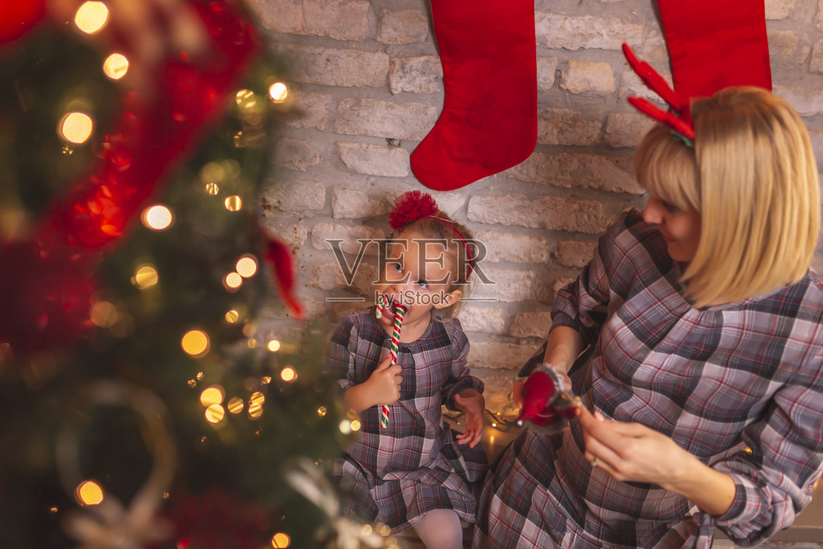 母亲和女儿在圣诞夜装饰圣诞树照片摄影图片