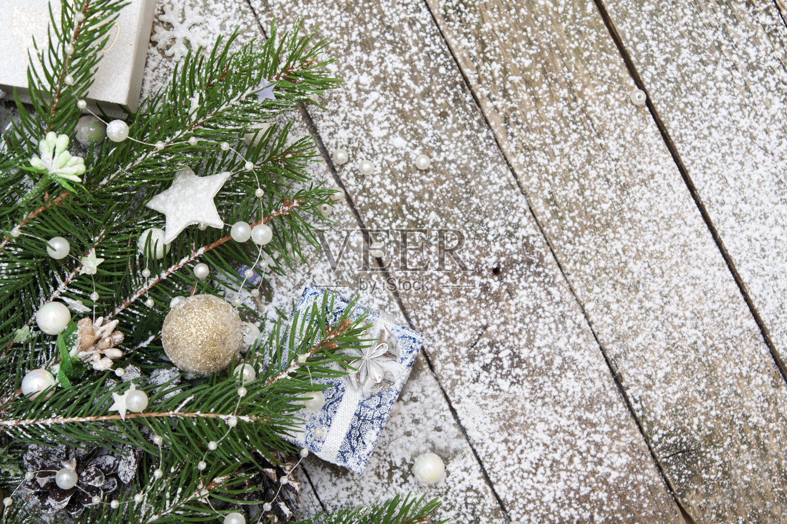 圣诞装饰,松木装饰,珠子,雪花,星星,礼物在一个雪白的木制背景-空白的新年贺卡与文字的地方照片摄影图片