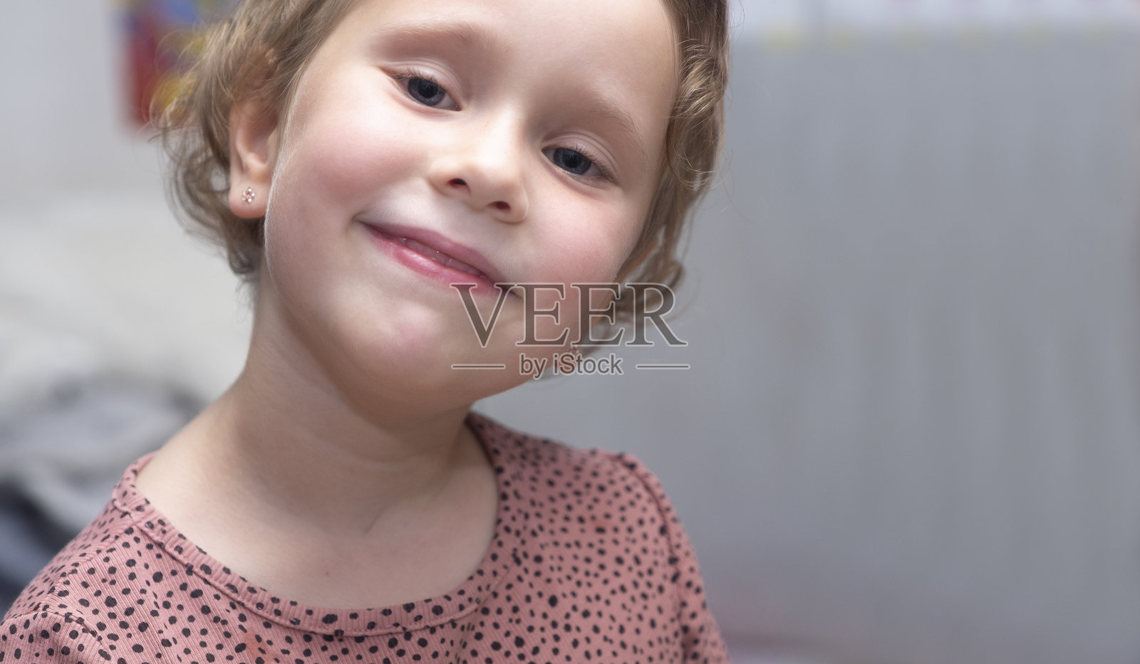 画像,白人女孩,5岁。一个可爱的婴儿微笑着看着镜头。金发,短头发。卷发。照片摄影图片