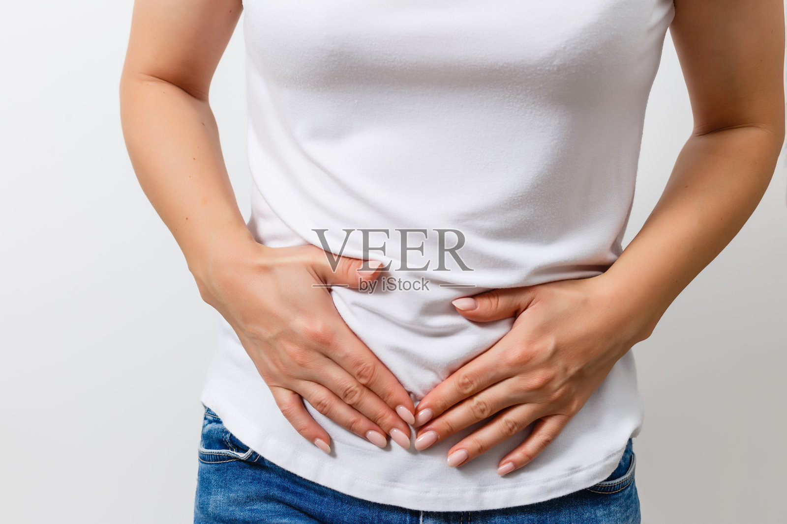 中年妇女胃痛在灰色的墙壁背景。照片摄影图片