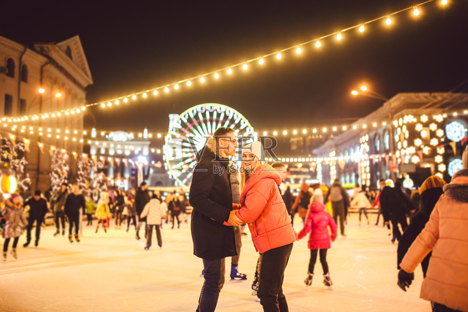 一起滑冰。浪漫的冰场寒假。一对年轻夫妇在溜冰场滑冰。最好的圣诞节。冬天的乐趣。可爱的情人节。新年与夫妇滑冰。寒假照片摄影图片
