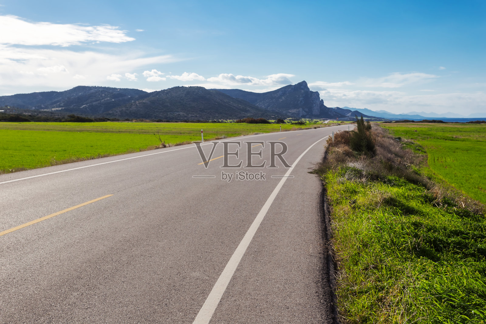 柏油路穿过一片绿色的田野照片摄影图片