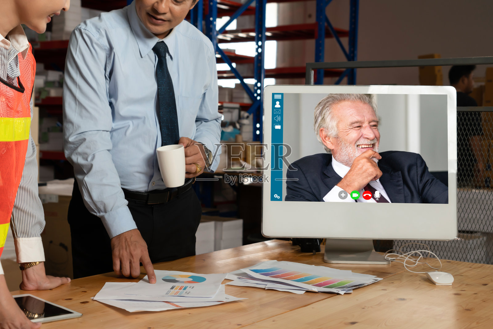 仓库工作人员在仓库的电脑屏幕上进行视频通话照片摄影图片