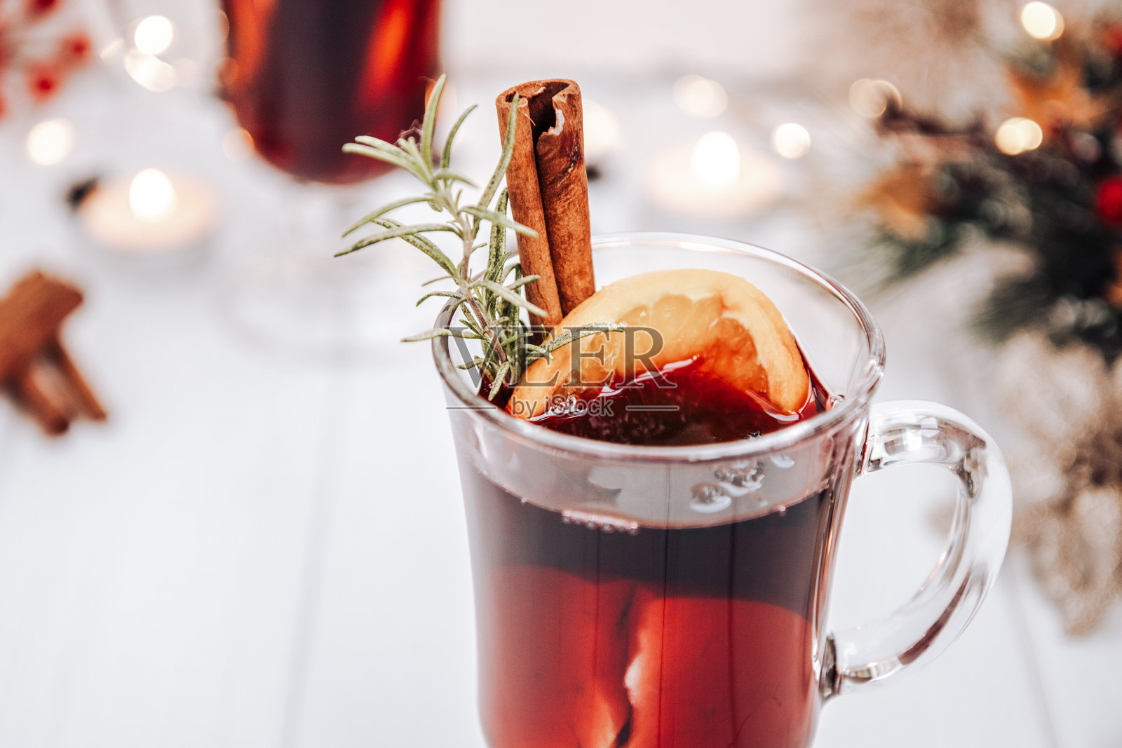 桌上放着一杯热红酒,周围是新年的灯光。喜庆心情,热红酒拉近照片摄影图片