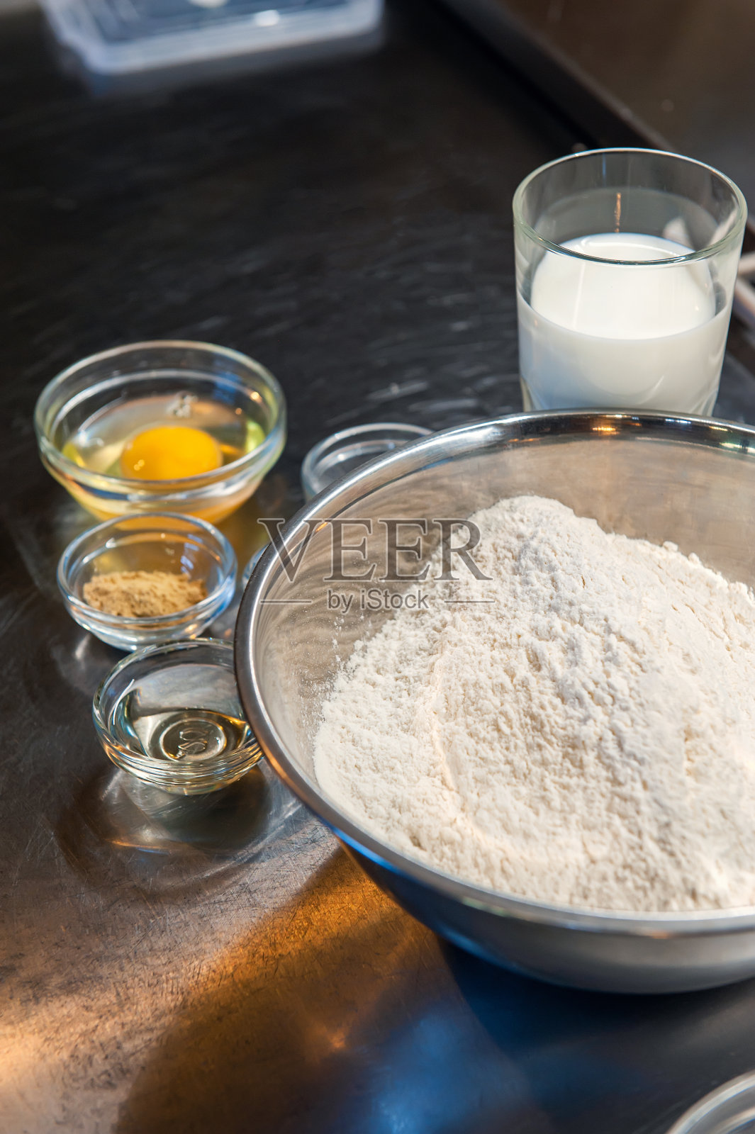 在乡村厨房里烤蛋糕——一份生面团的配方,把鸡蛋、面粉、牛奶、黄油、糖和酵母放在桌上。制作面团的原料照片摄影图片