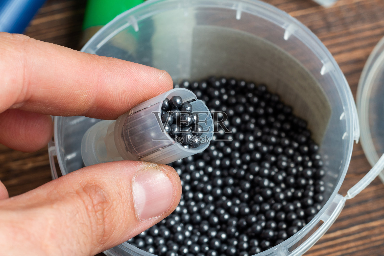 用特殊的装填装备重新装填猎枪弹药。火药,子弹,碎片,炮弹,铅弹在木头背景上照片摄影图片