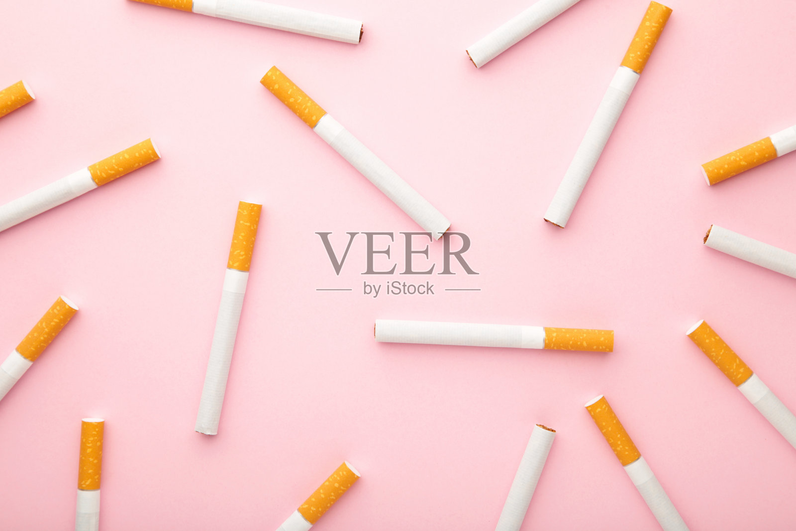 许多香烟以粉红色为背景。前视图。照片摄影图片