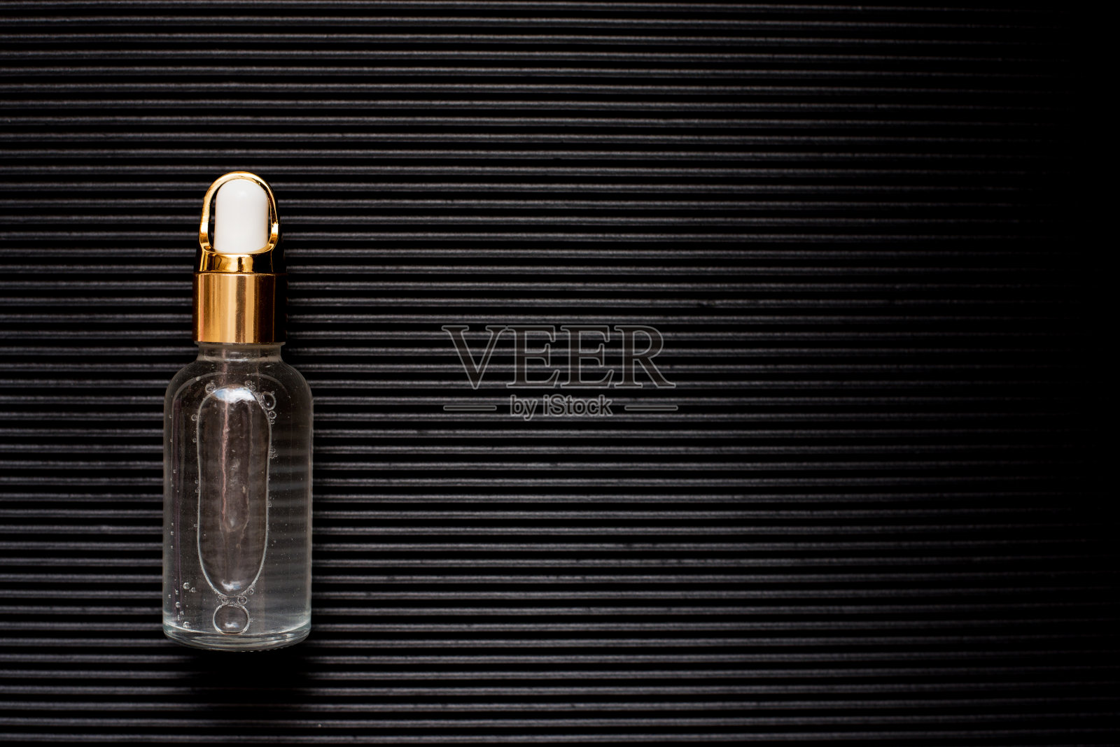 化妆油的瓶子上有纹理的黑色背景照片摄影图片