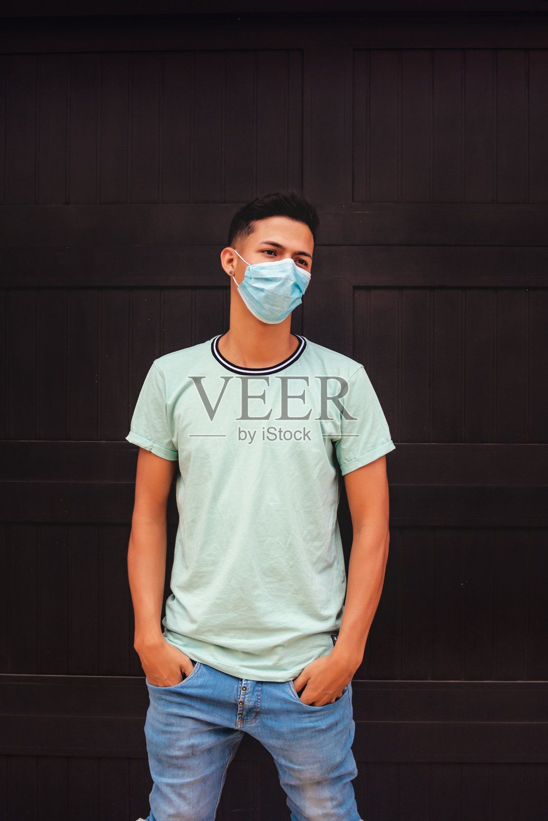 年轻人戴着黑色墙壁面具,浅蓝色衬衫照片摄影图片