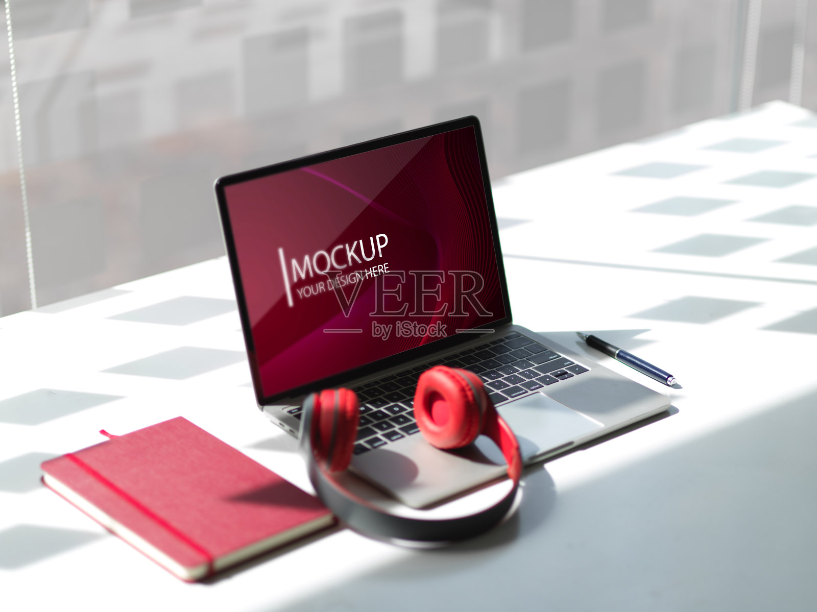 在共同工作空间的白色桌上模拟笔记本电脑,耳机和笔记本电脑照片摄影图片
