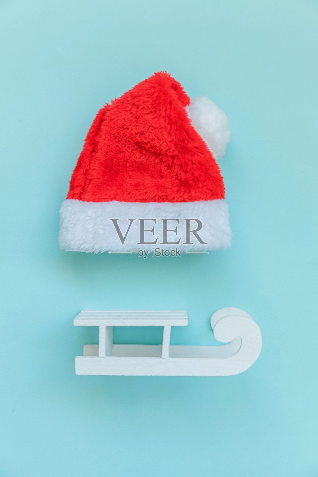 简单简约的圣诞老人帽雪橇孤立在蓝色粉彩缤纷的时尚背景上照片摄影图片