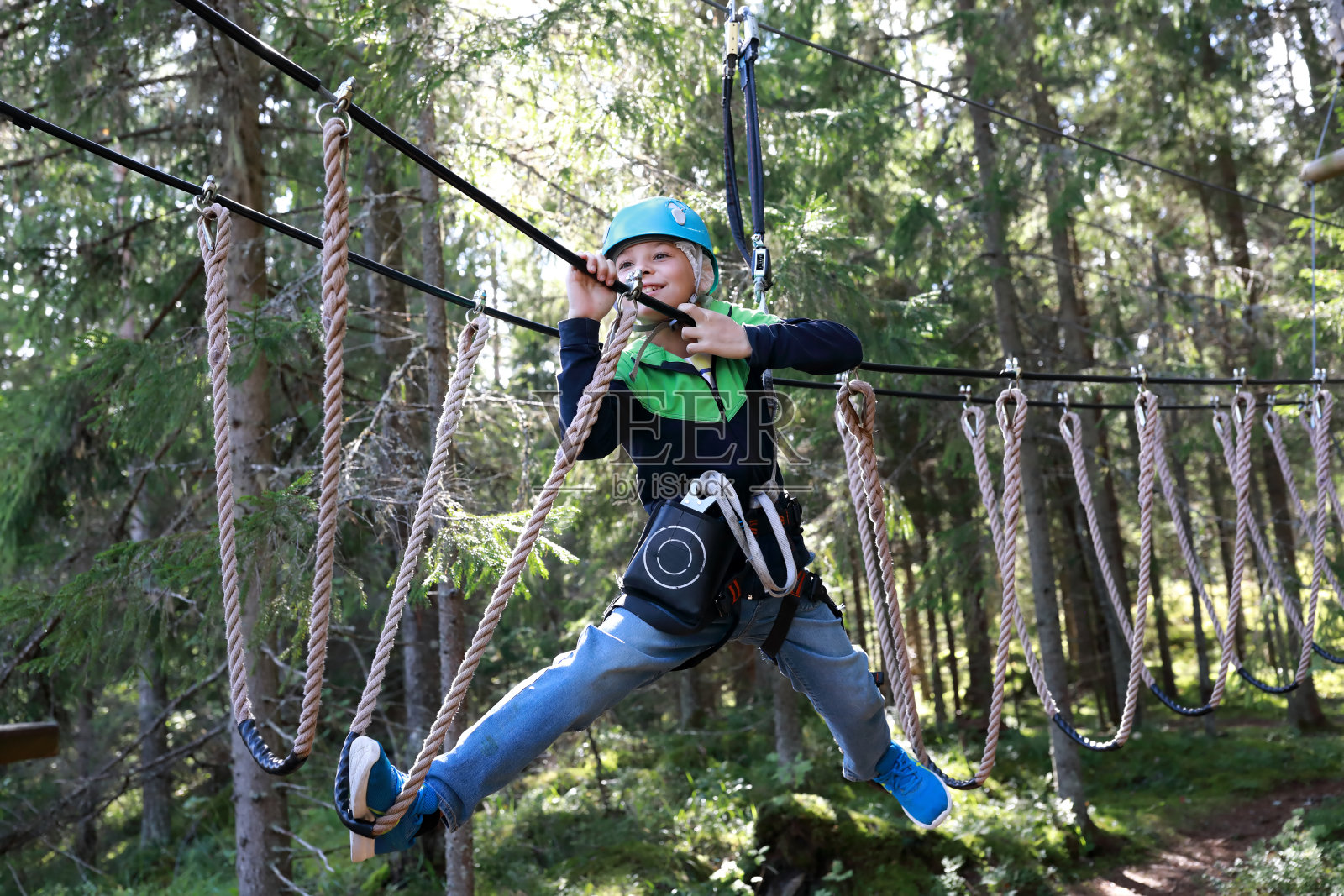 克服悬吊绳索障碍的孩子照片摄影图片