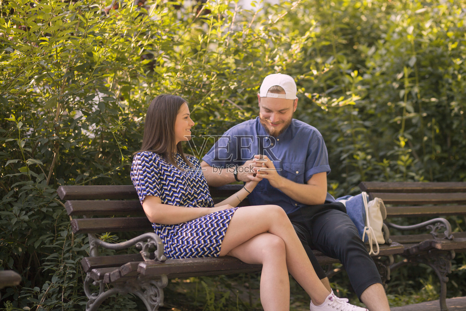 一对可爱的夫妇在公园的长椅上。照片摄影图片