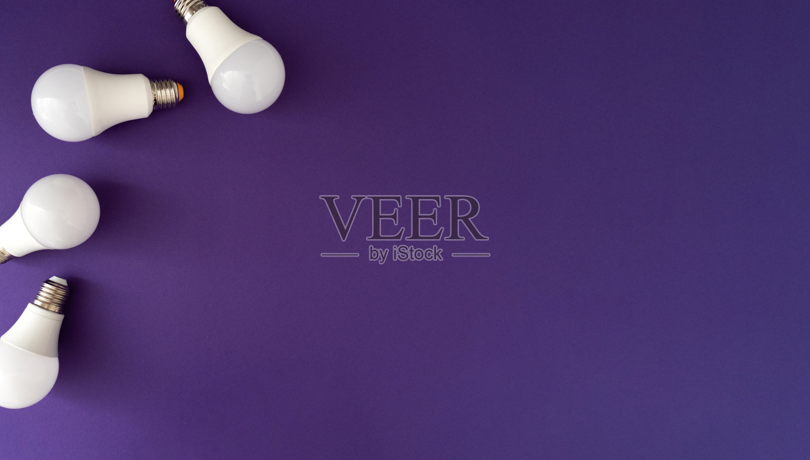 紫色背景上的四个白色led灯泡,平放,近距离,拷贝空间照片摄影图片