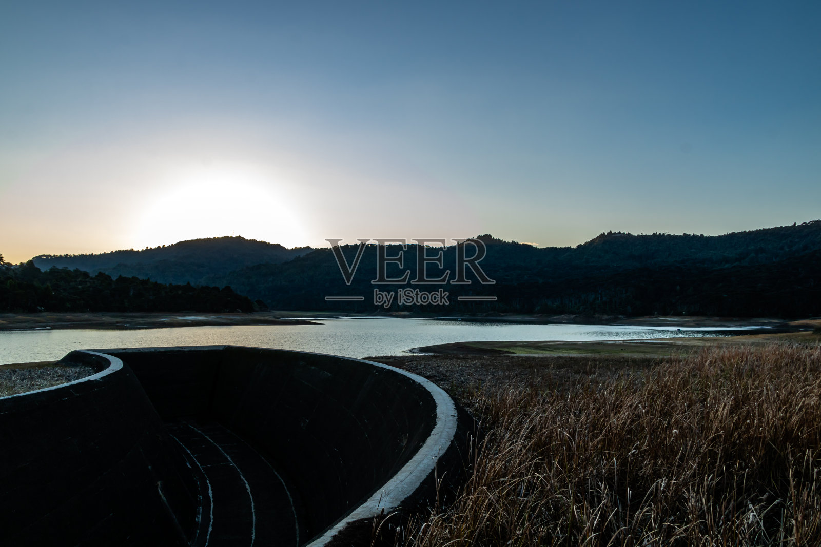 太阳正落在怀塔克里大坝上。奥克兰,新西兰照片摄影图片