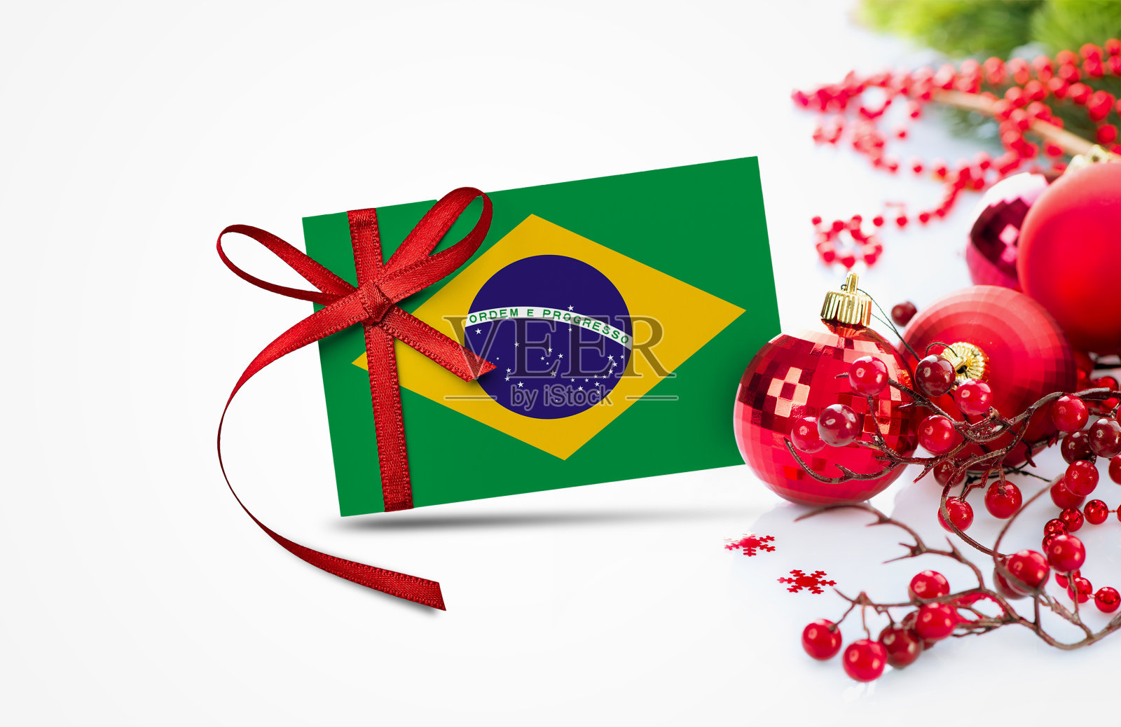 巴西国旗上的新年邀请卡与红色圣诞装饰品的概念。全国欢度新年作文。照片摄影图片