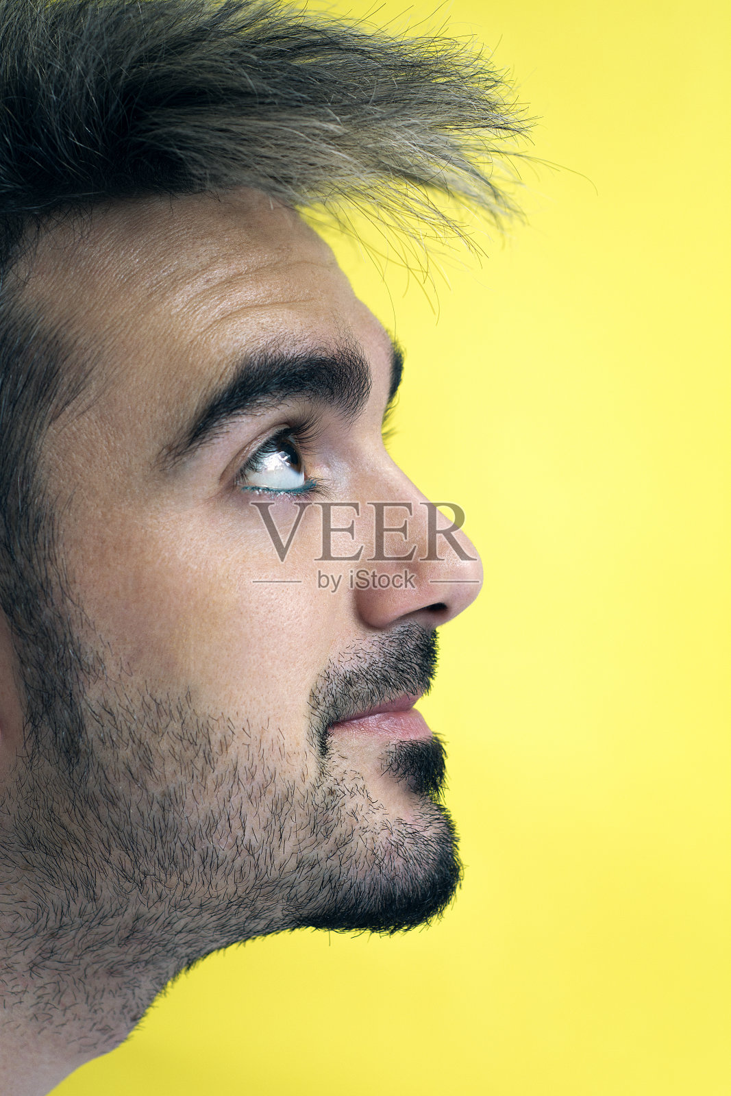 一个黄色背景的年轻男子的侧面特写照片摄影图片