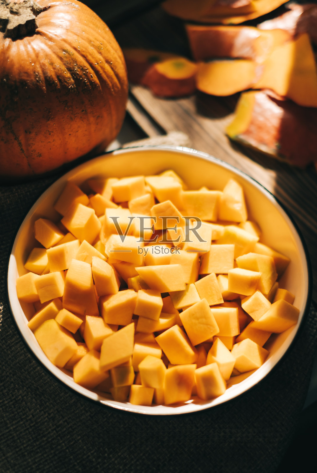 近距离观看新鲜,生动的橙色南瓜片在一个白色的盘子。照片摄影图片