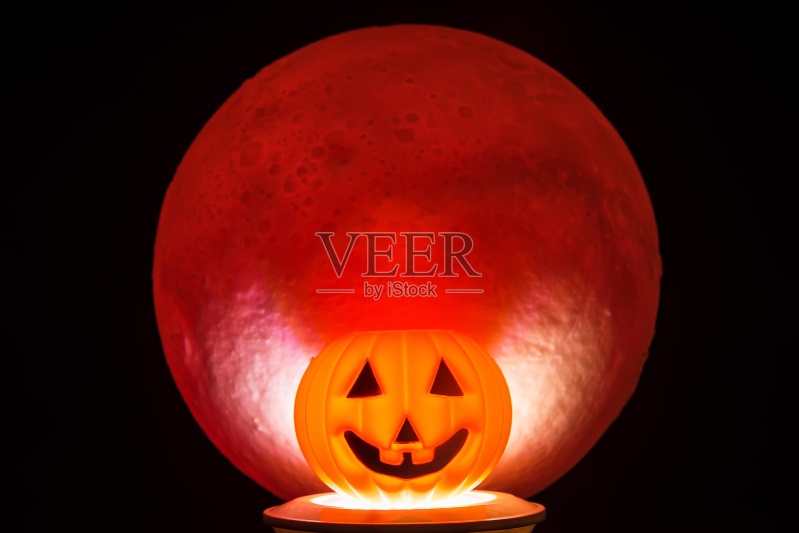 万圣节的恐怖或可怕的南瓜。背景中有一轮红色的满月。万圣节恐怖的概念。照片摄影图片