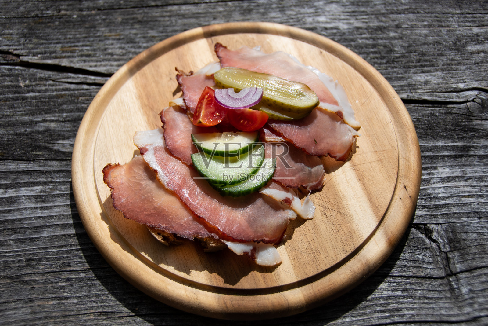 新鲜美味的面包配上熏肉、黄瓜、西红柿和红洋葱照片摄影图片