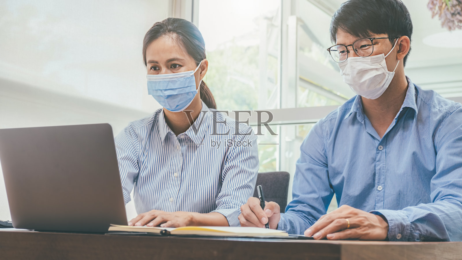 亚洲人成功的团队合作,戴着医用口罩工作。新冠肺炎疫情中私人办公室社交距离的工作照片摄影图片