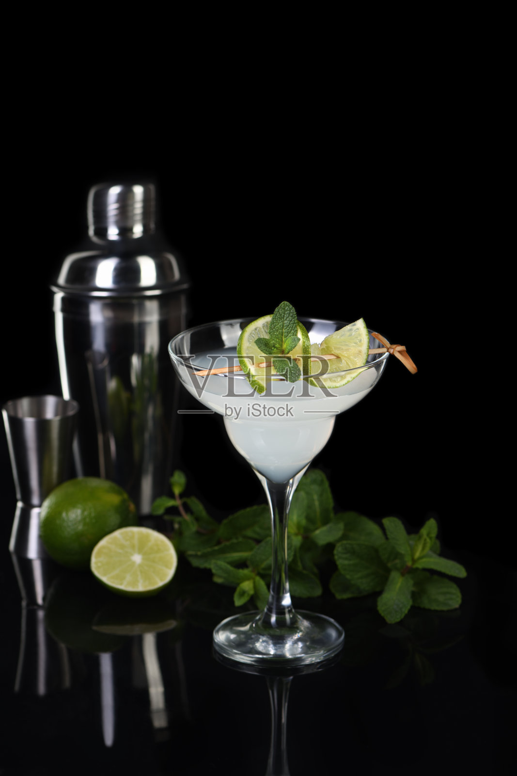 玛格丽特鸡尾酒:龙舌兰酒、柑橘利口酒和青柠汁,饰以薄荷照片摄影图片