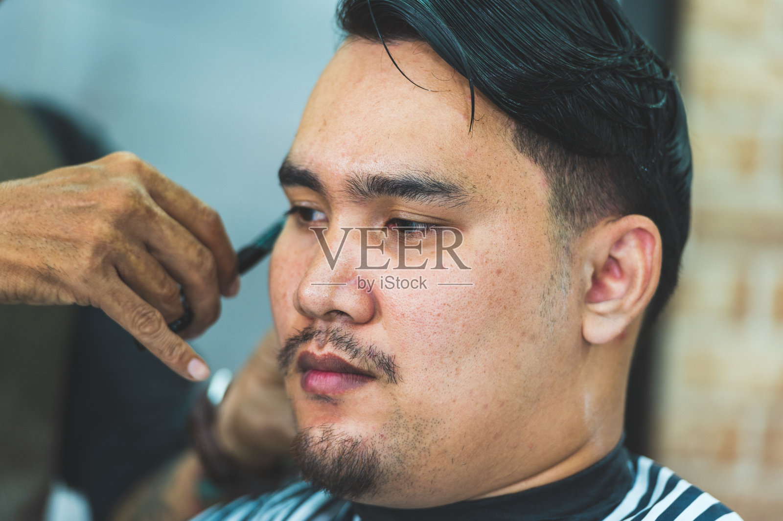 成年男子时尚发型师在理发店为顾客理发照片摄影图片