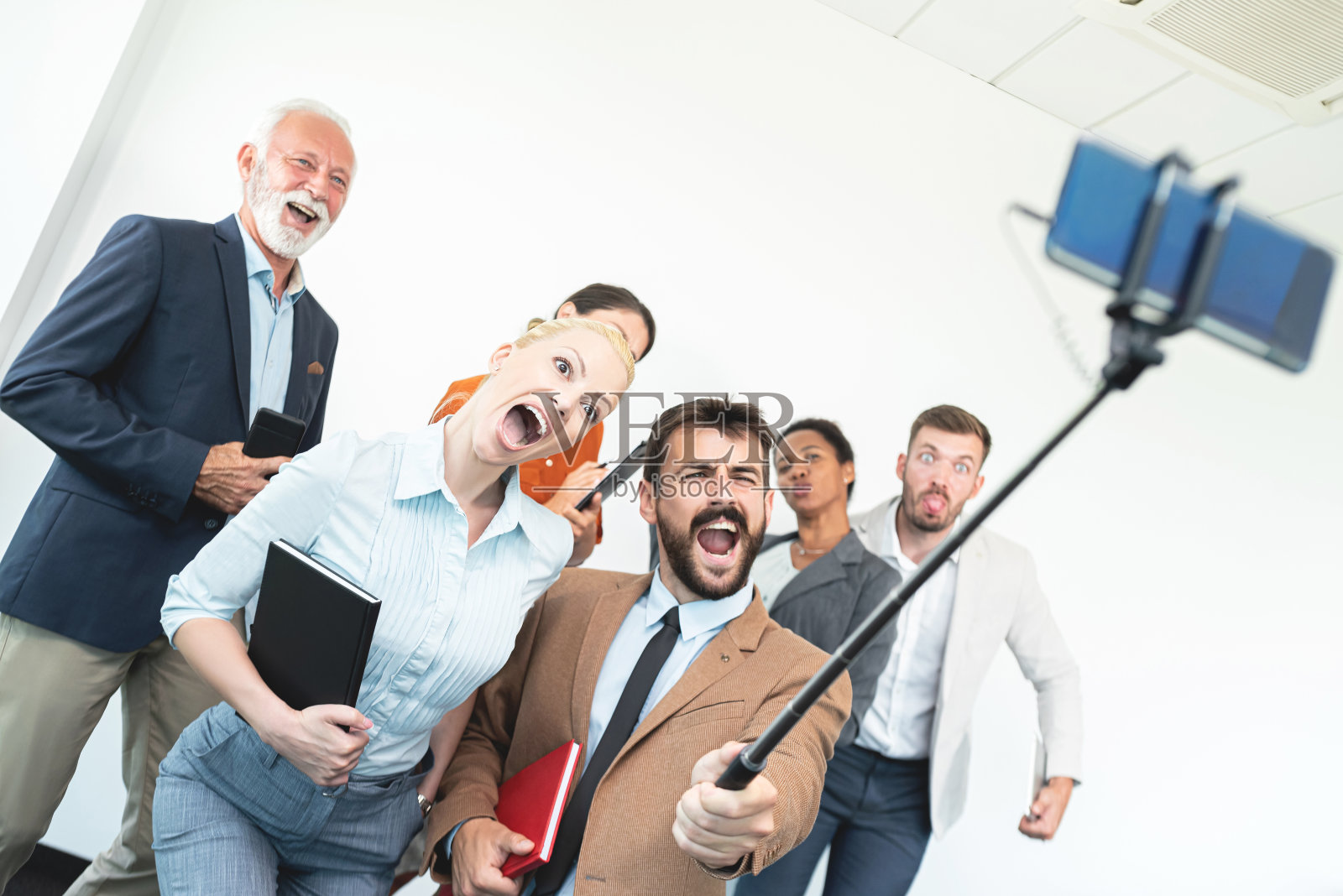 一群商业人士在做鬼脸和自拍照片摄影图片