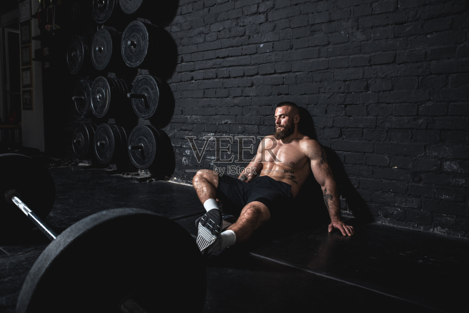 年轻强壮的fit出汗的肌肉男人坐在健身房的地板后杠铃举重锻炼和休息从硬核交叉训练真人照片摄影图片