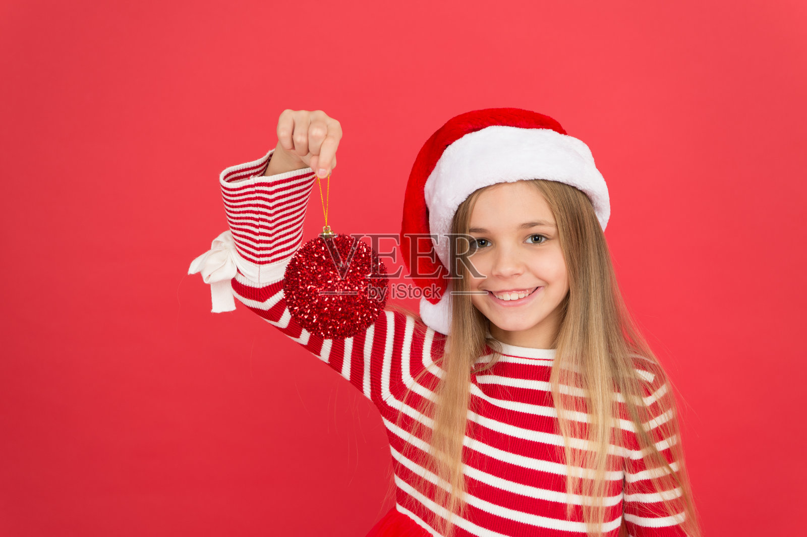 装饰给你带来节日的欢乐。快乐的孩子抱着亮闪闪的红球装饰。球的点缀和装饰。节日装饰。最喜欢的圣诞装饰。装饰圣诞树的最佳方式照片摄影图片