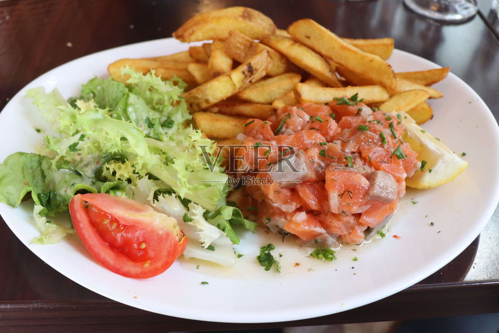 三文鱼鞑靼配薯条和沙拉照片摄影图片