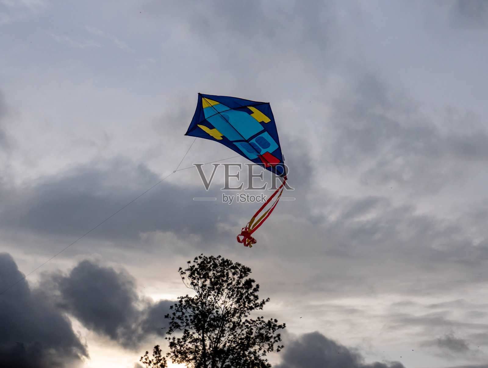 风筝在秋天灰色的天空下飞翔照片摄影图片